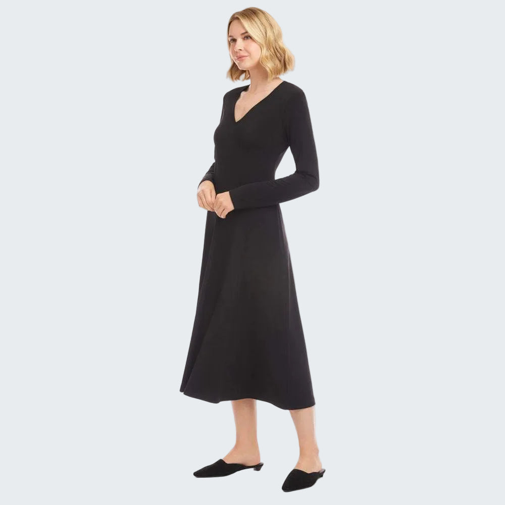 A woman modeling a long-sleeve black midi dress with a V-neckline, shown against a plain white studio background.