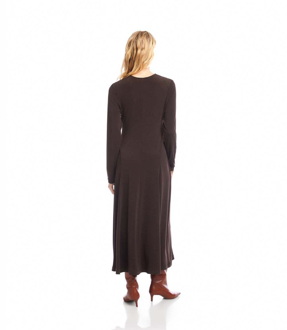 A woman viewed from behind wearing a dark brown long-sleeve midi dress and brown heeled boots against a plain white studio background.