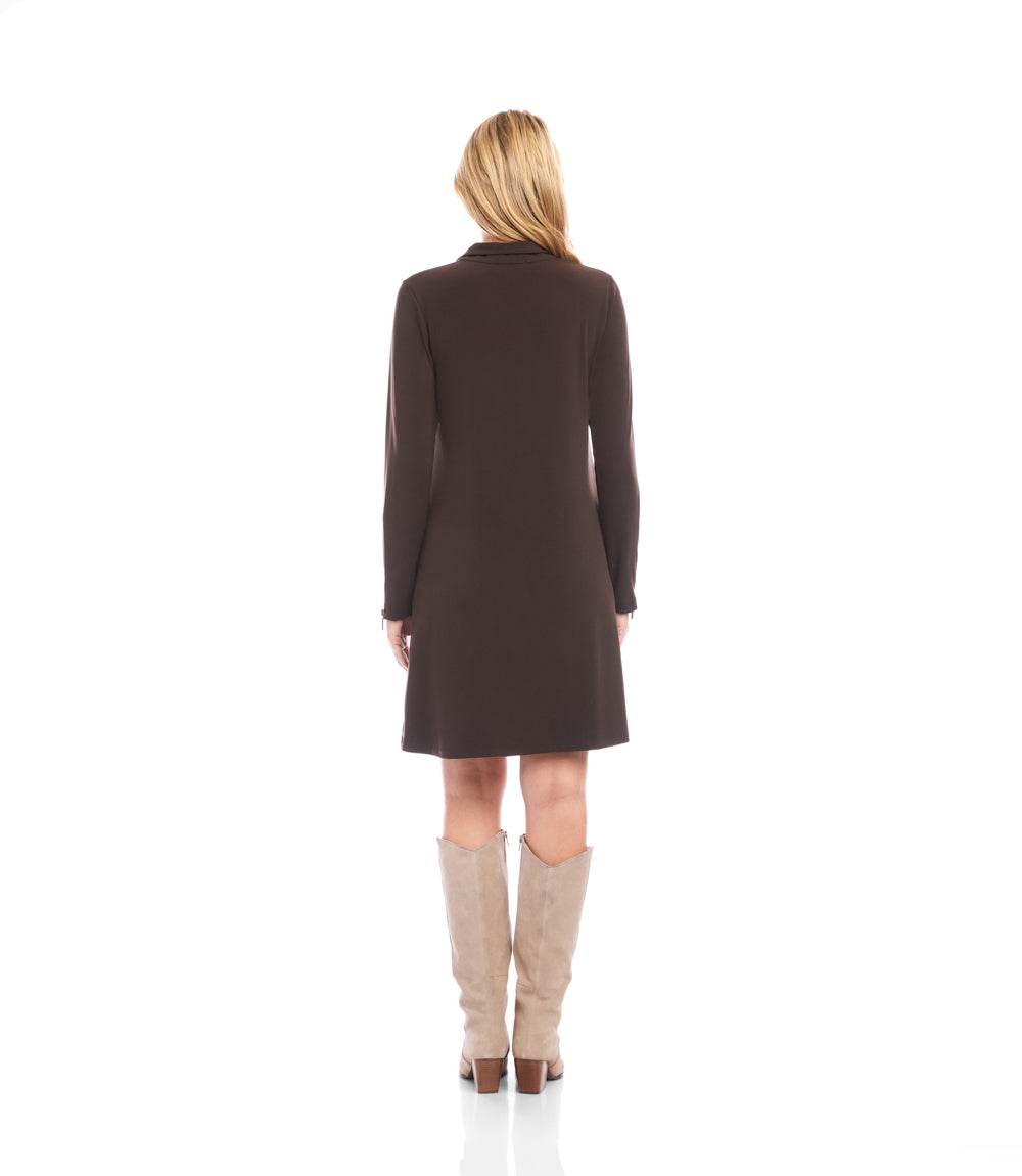 A woman viewed from the back wearing a dark brown long-sleeve knee-length dress and beige knee-high boots against a plain white background.