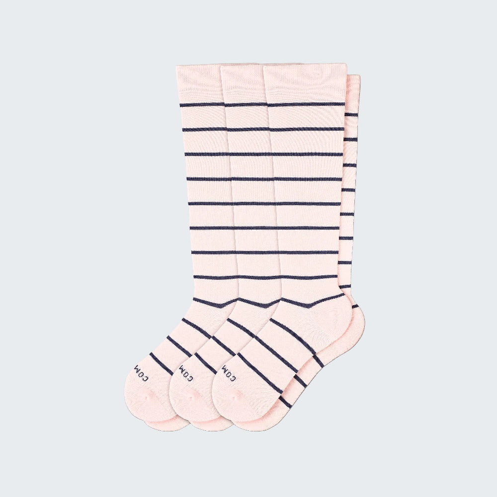 Set of three pairs of pink socks with black stripes on a white background