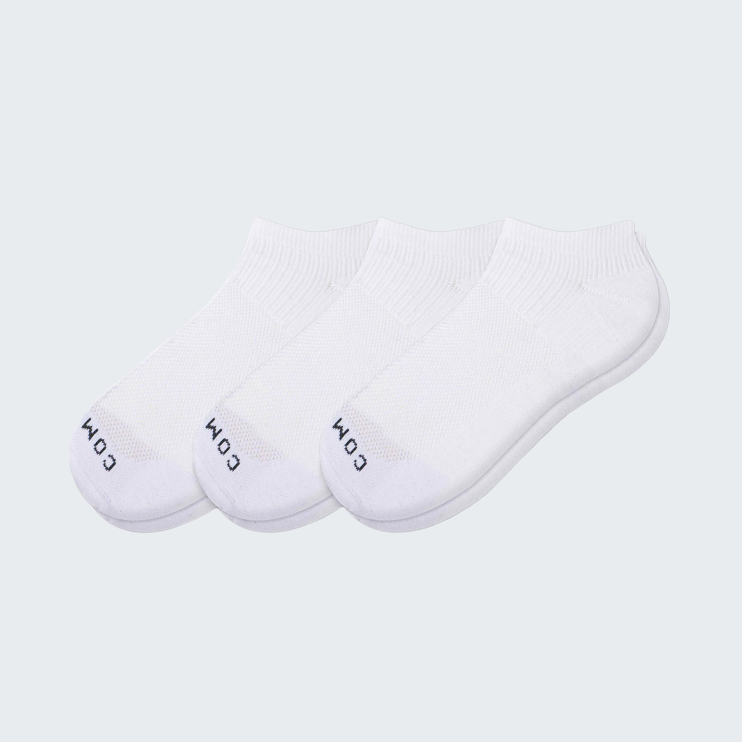 Three pairs of white ankle socks on a white background