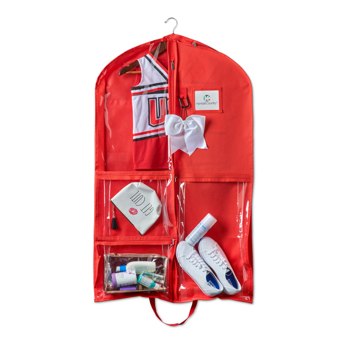 Red garment bag with clear front pocket containing a shirt, shoes, and accessories on a white background