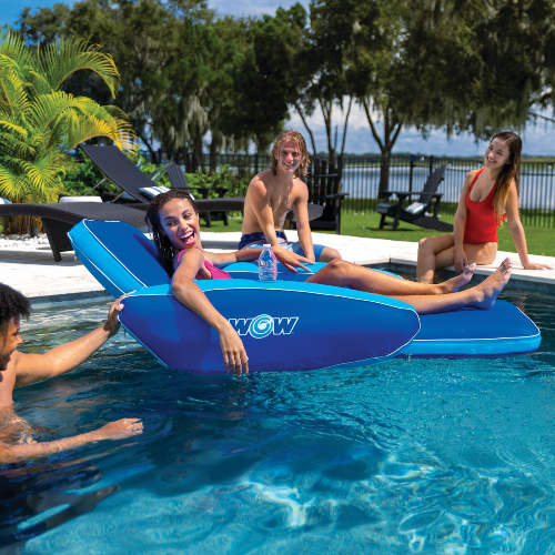 People enjoying a pool party with a blue inflatable platform in a pool.