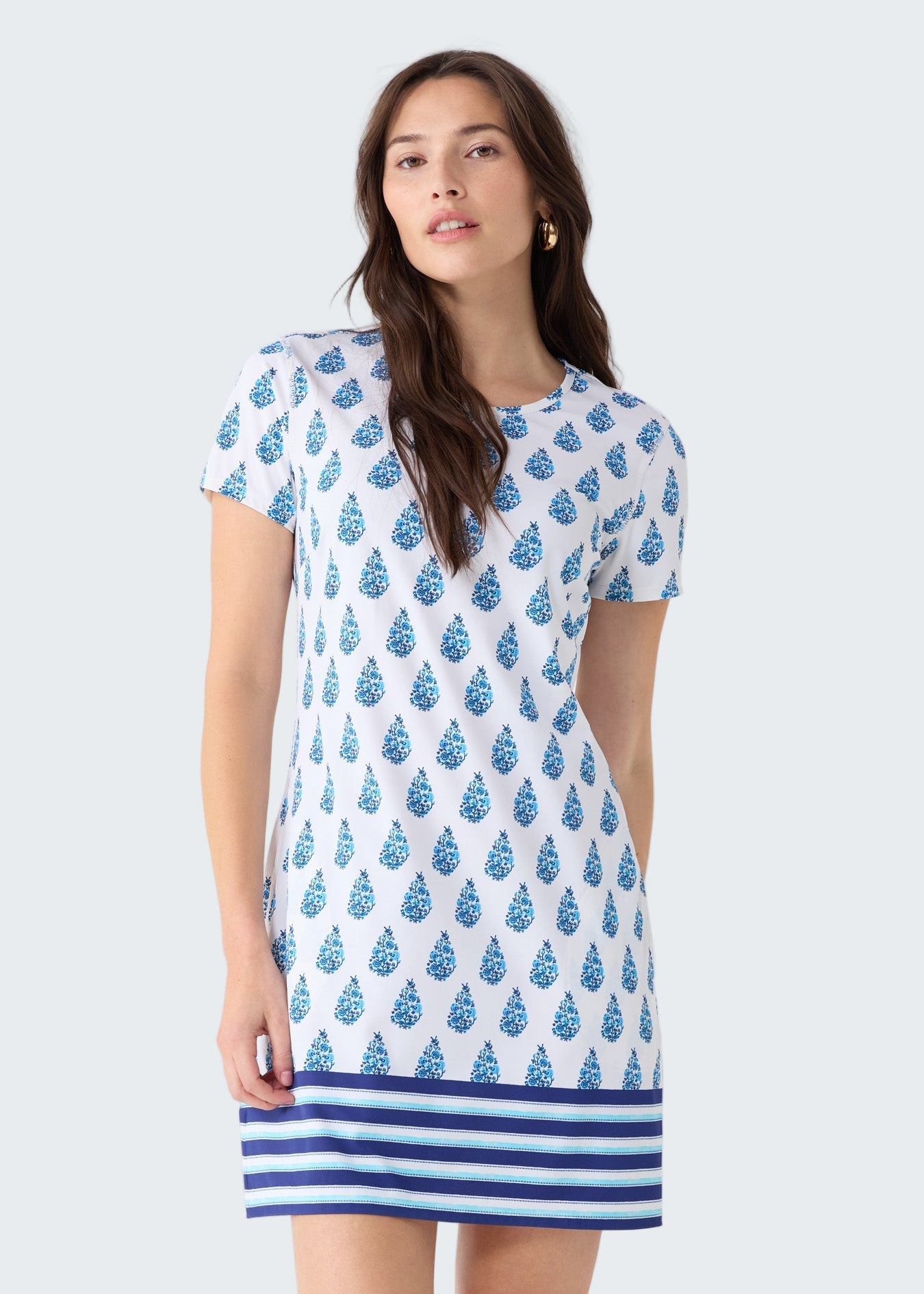 Woman wearing a blue and white patterned dress on a light gray background