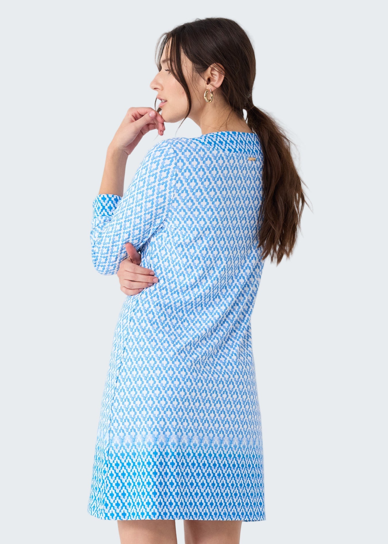 Woman wearing a blue patterned dress on a white background