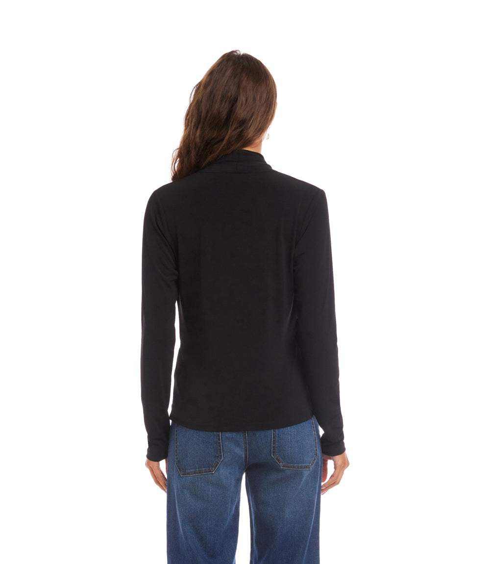 A woman viewed from the back wearing a black long-sleeve mock neck top and blue jeans against a plain white background.