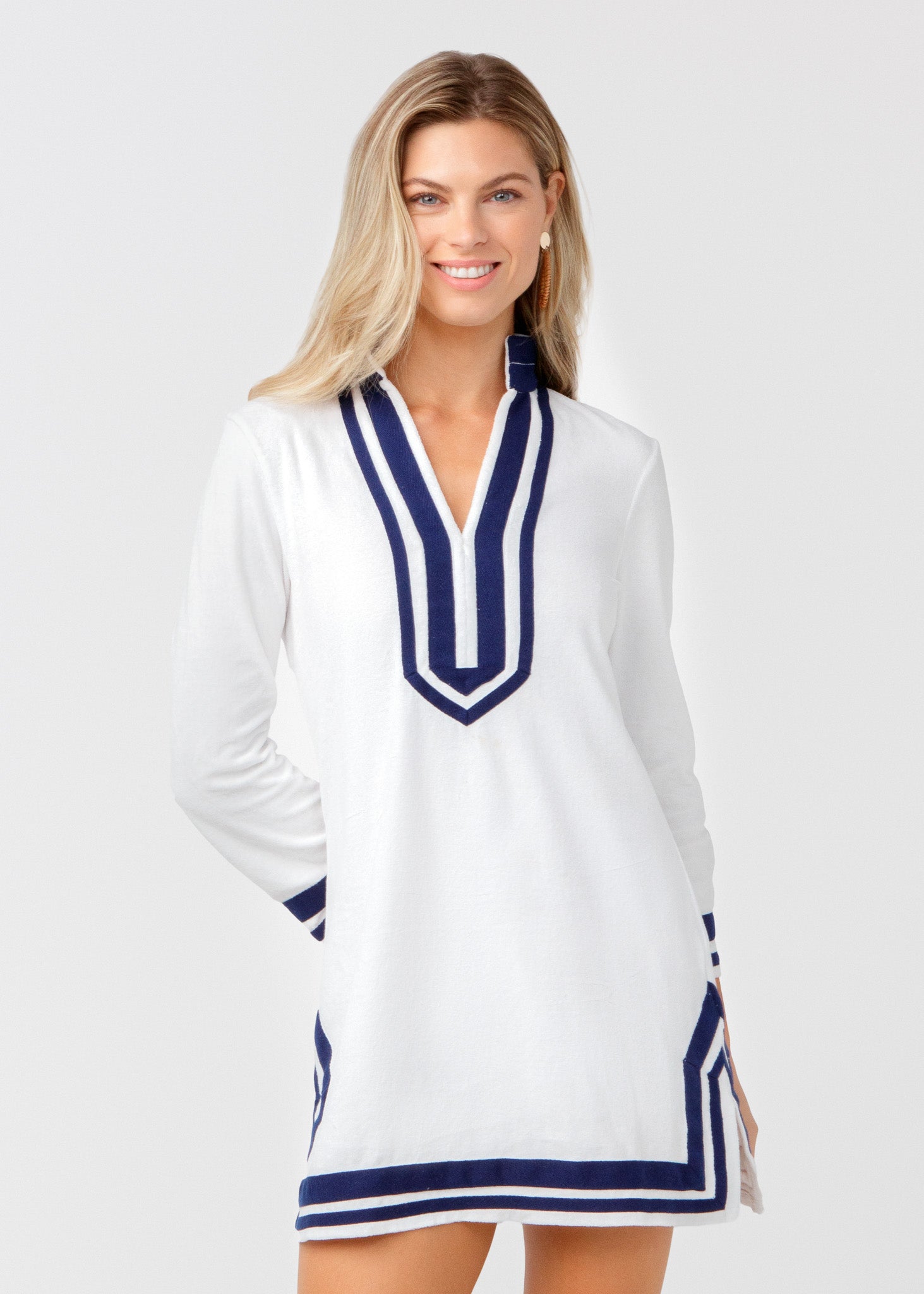 Woman wearing a white dress with blue accents on a light gray background