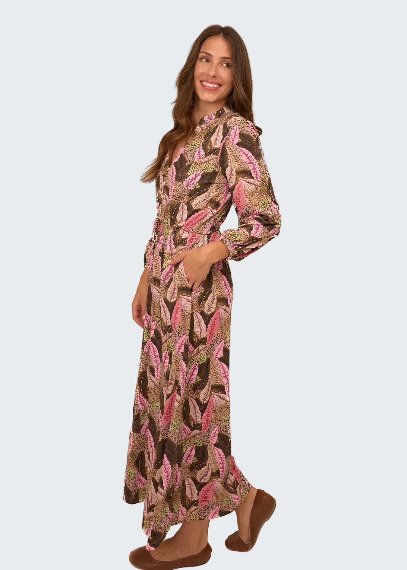 Woman wearing a long, patterned dress on a white background