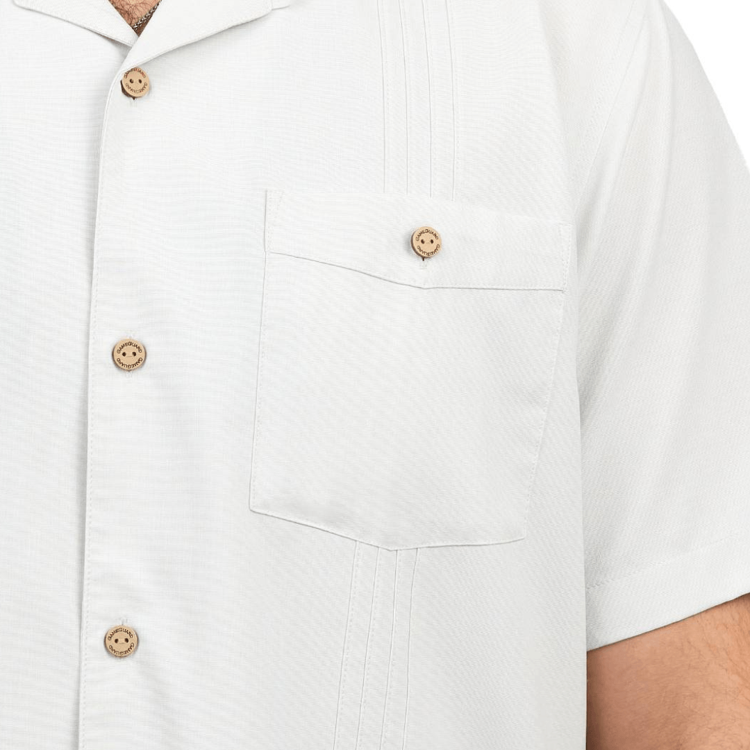 Close-up of a white shirt with brown buttons on a plain background