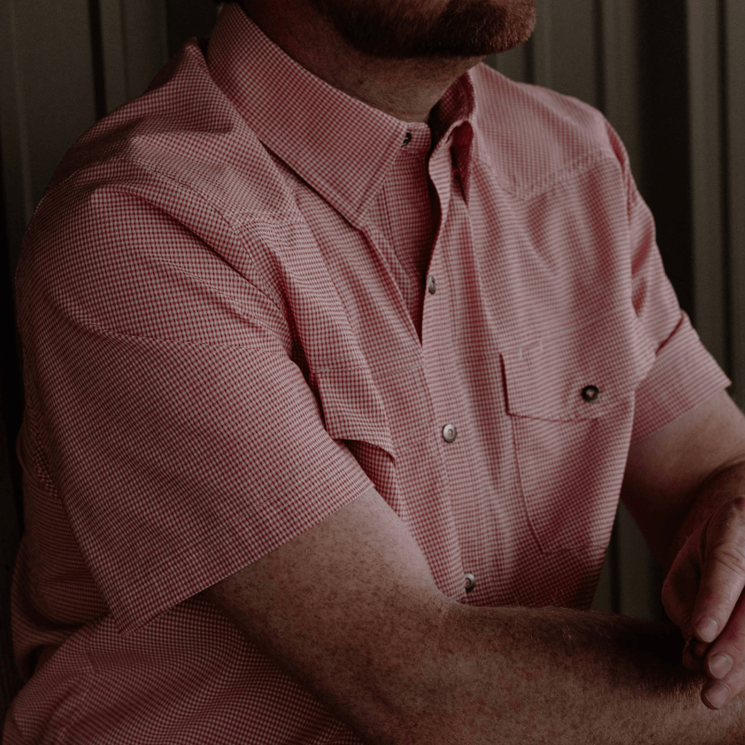 Person wearing a red checkered shirt with a blurred background