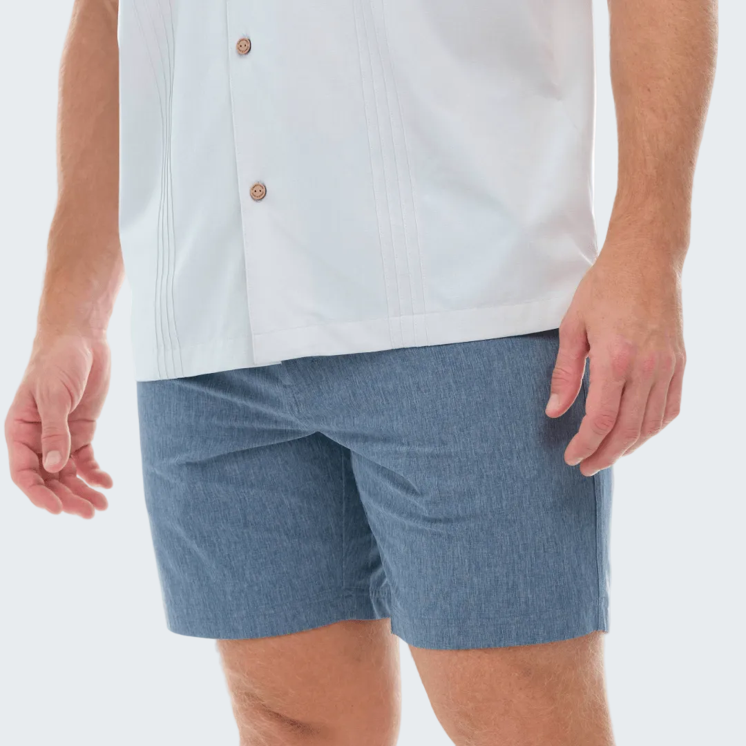 Person wearing a light blue shirt and blue shorts on a white background