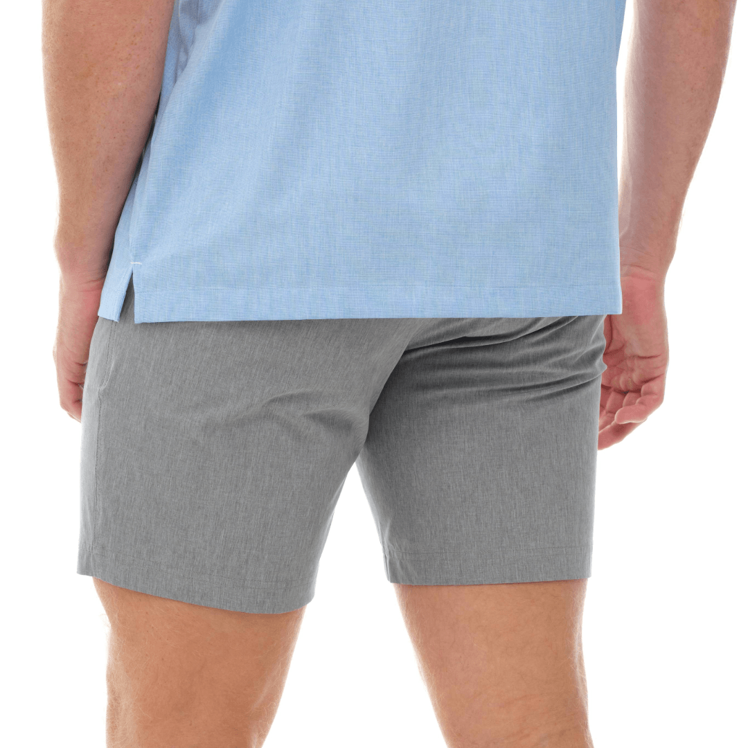 Person wearing gray shorts and a light blue shirt on a white background