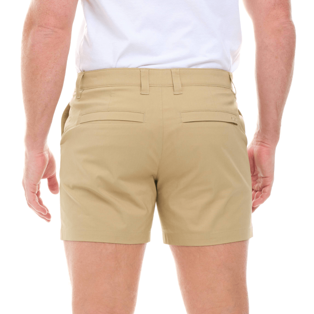 Beige shorts worn by a person on a white background
