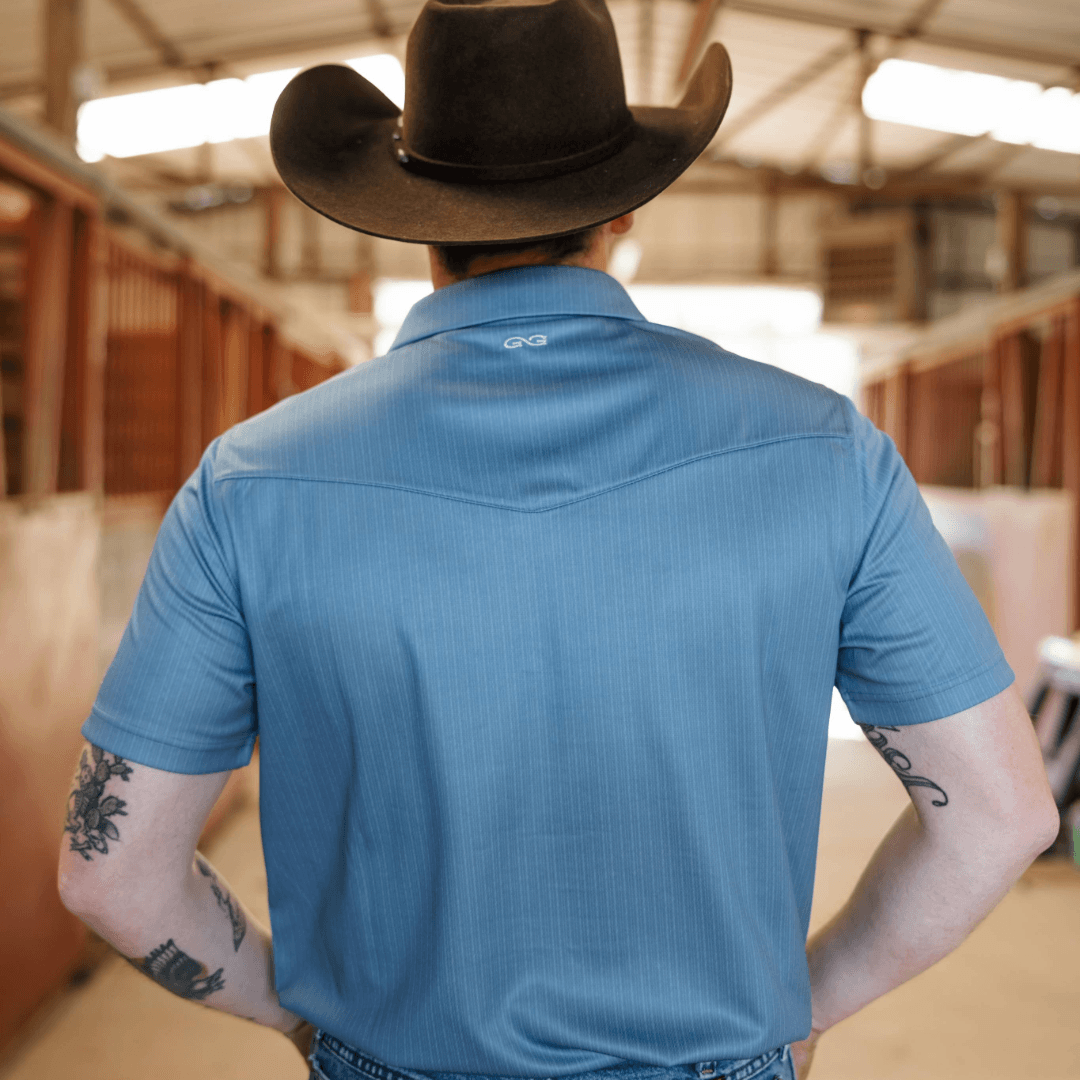 Person wearing a blue shirt with a brand logo in an indoor setting