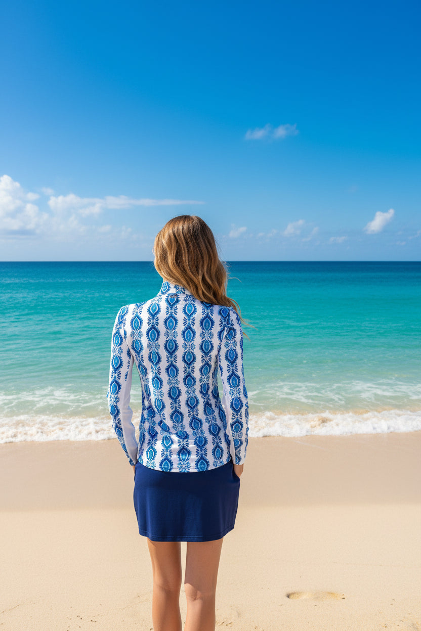 Woman wearing a blue and white patterned blouse with a navy skirt on a white background