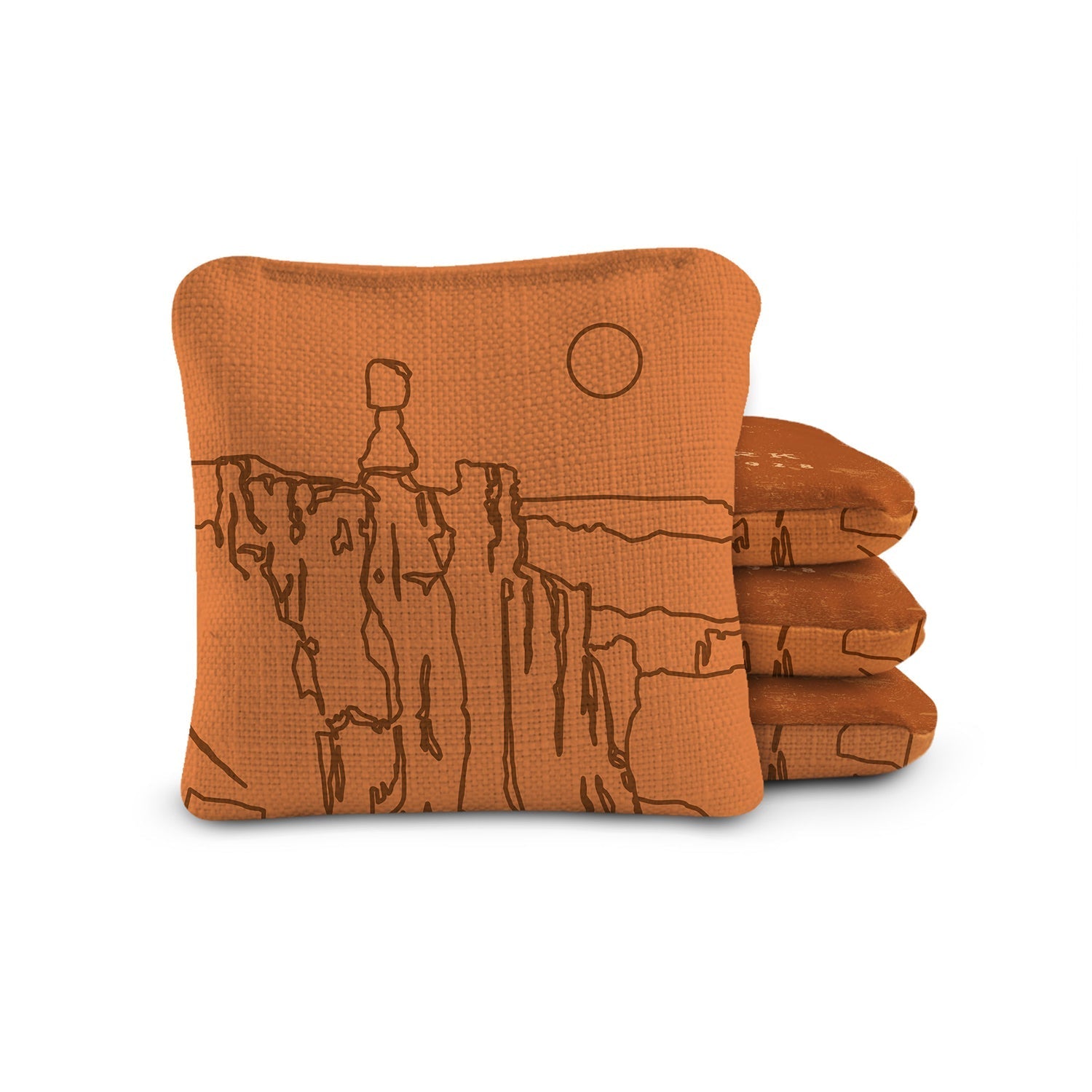 Stack of orange towels with desert landscape design on a white background