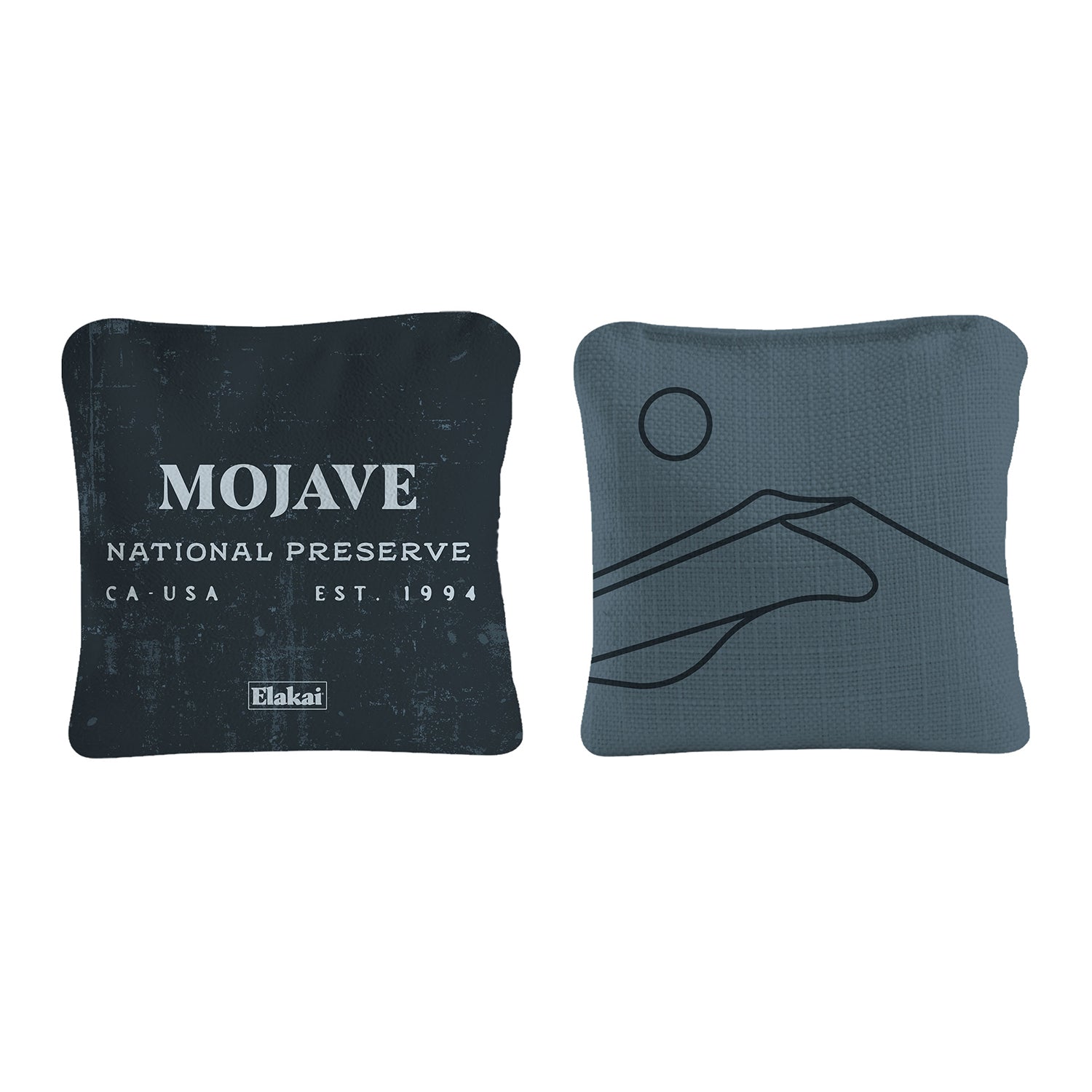 Two square pillows, one with 'Mojave National Preserve' text and the other with a hand design, on a white background.