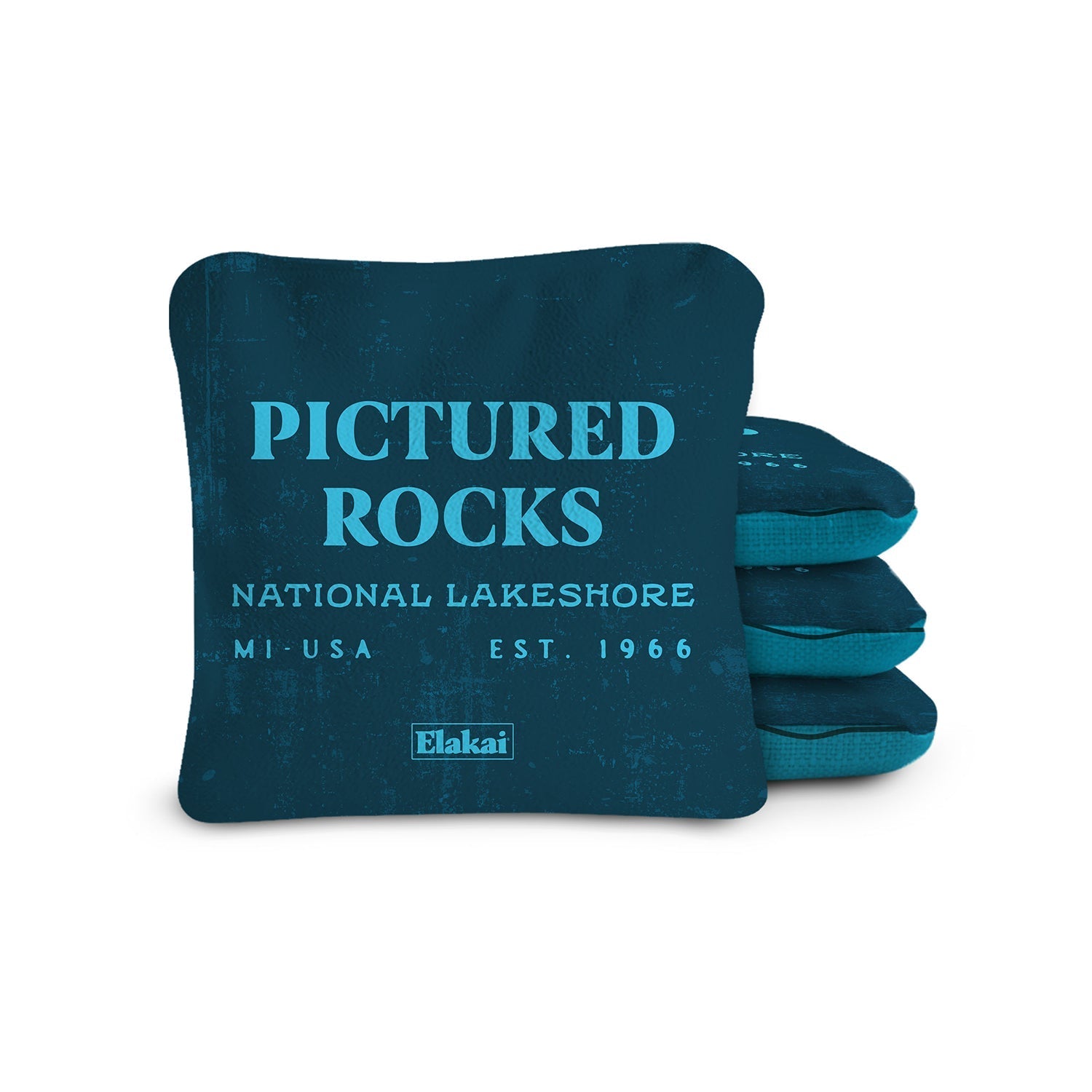 Blue pillow with 'Pictured Rocks National Lakeshore' text and Elakai branding on a white background
