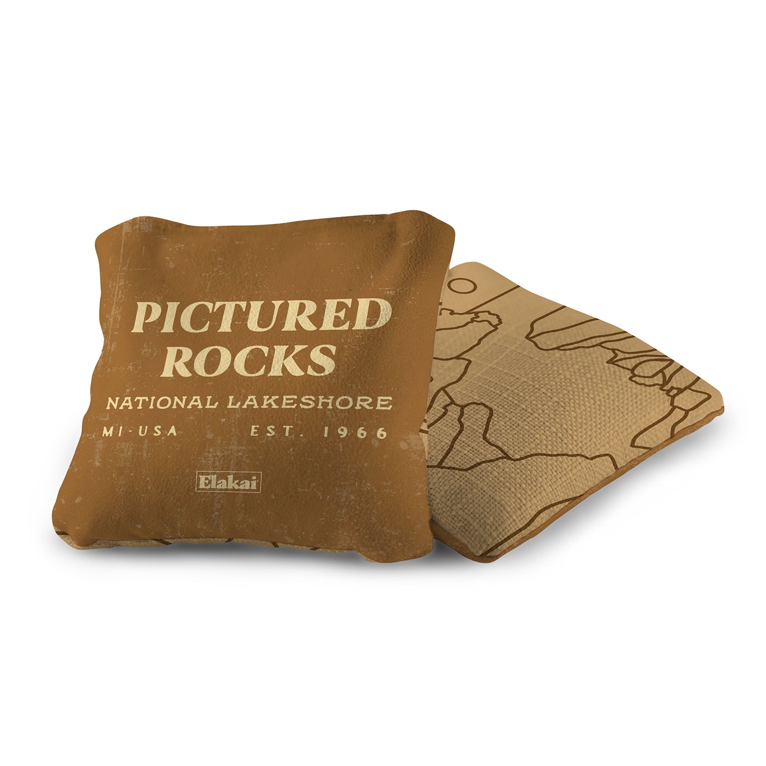 Brown pillow with 'Pictured Rocks National Lakeshore' text and map design on a white background