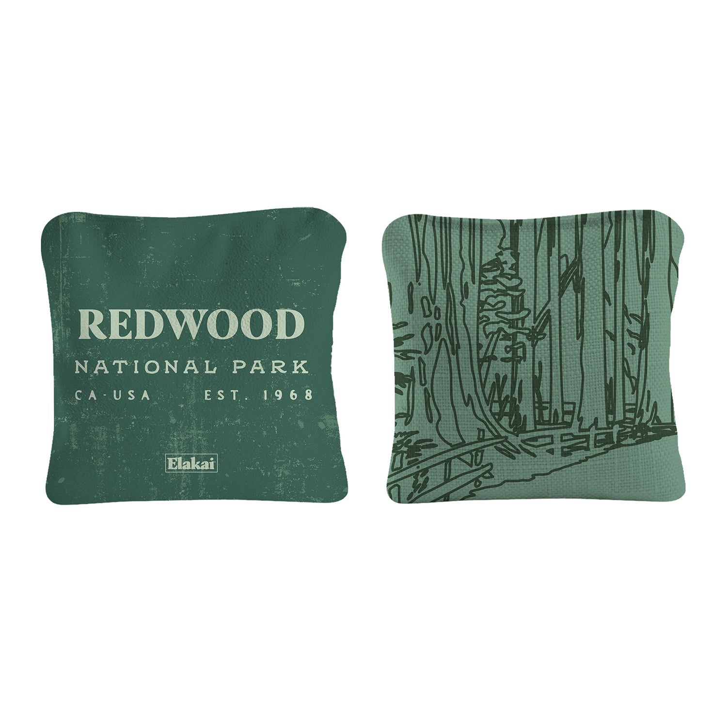 Two square decorative pillows shown side by side on a white background. The left pillow is dark green with distressed white text reading 'REDWOOD NATIONAL PARK', 'CA-USA', 'EST.