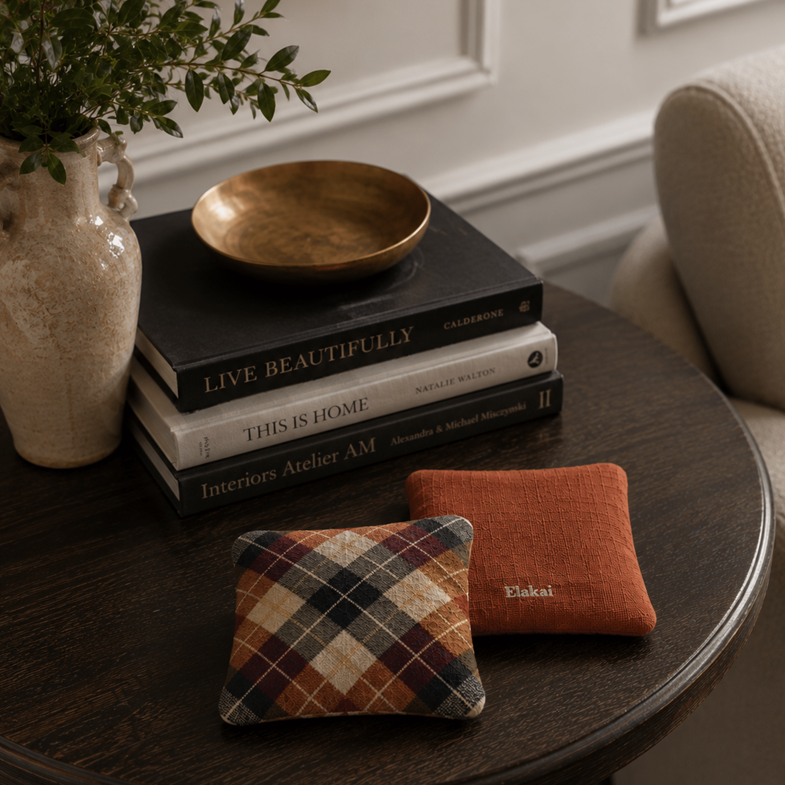 Decorative items on a table including books, a bowl, and two textured pillows.