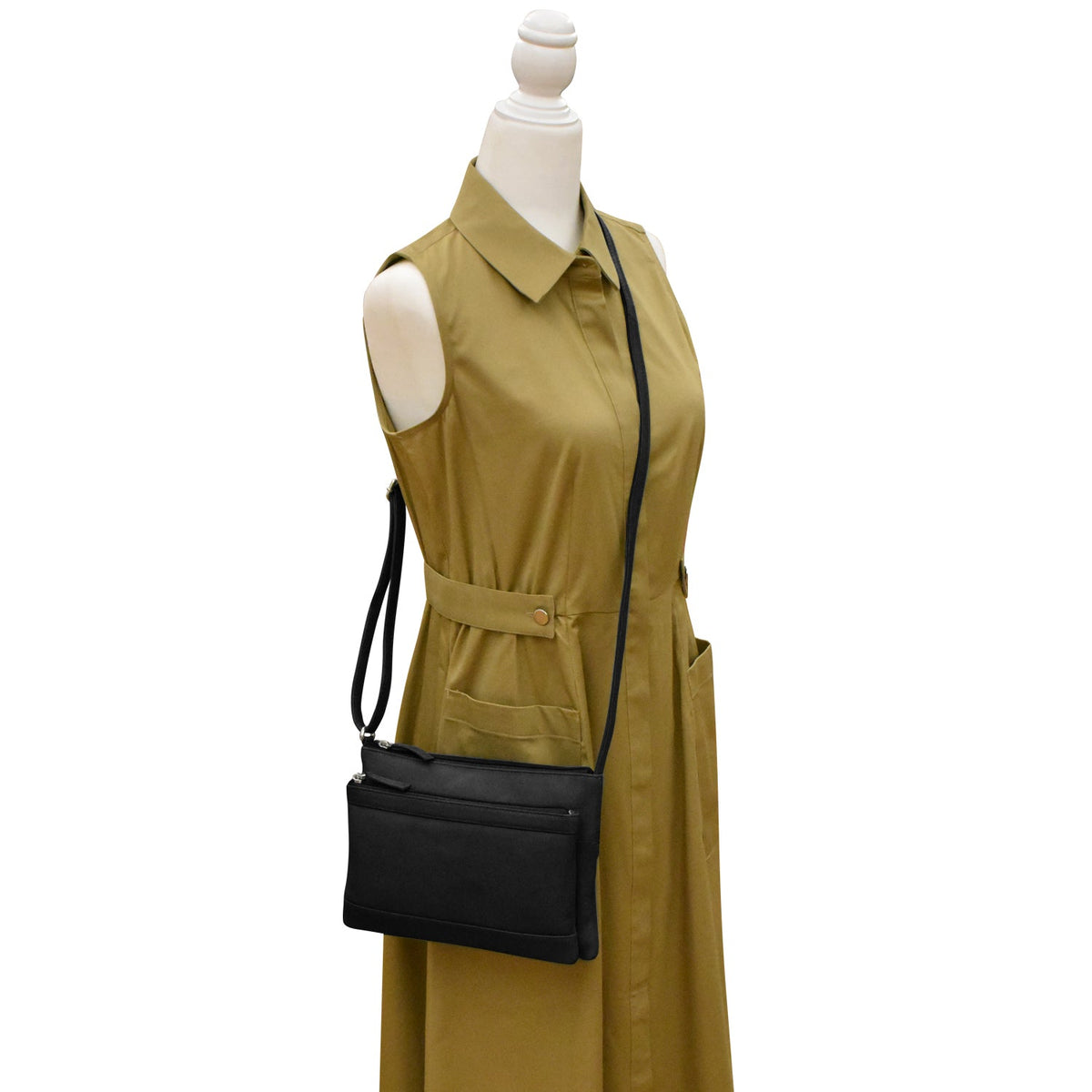Mannequin wearing a green dress with a black handbag on a white background