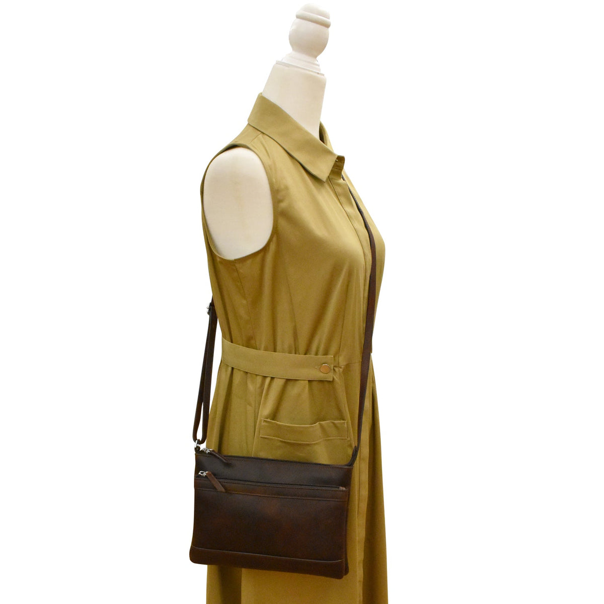 Mannequin wearing a mustard yellow dress with a brown bag on a white background