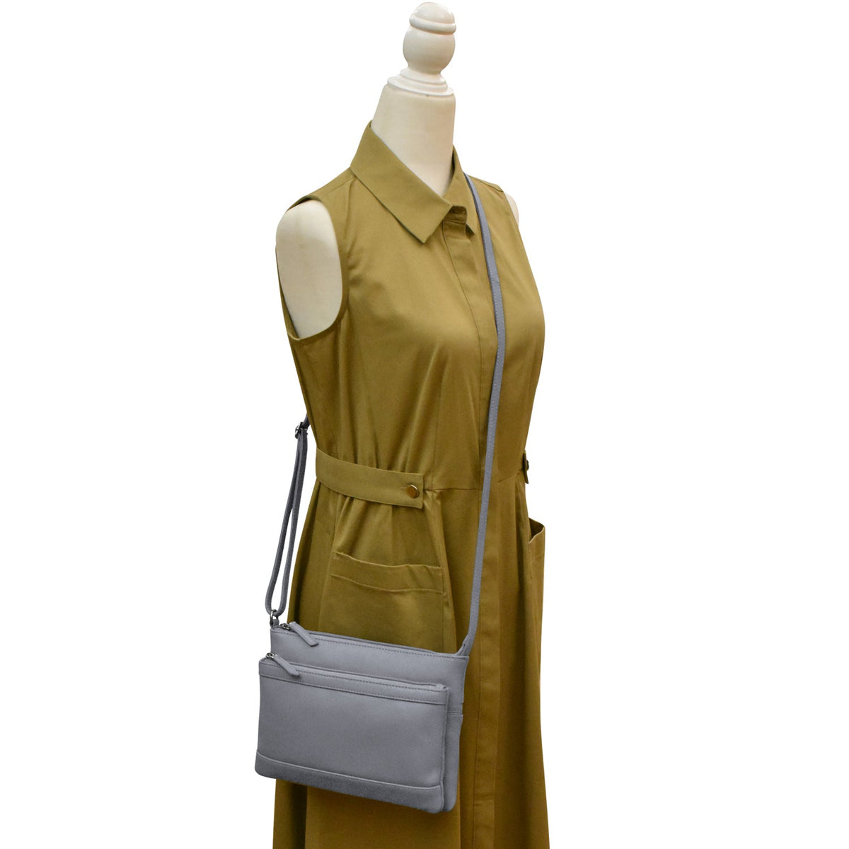 Mannequin wearing a mustard yellow dress with a gray crossbody bag on a white background