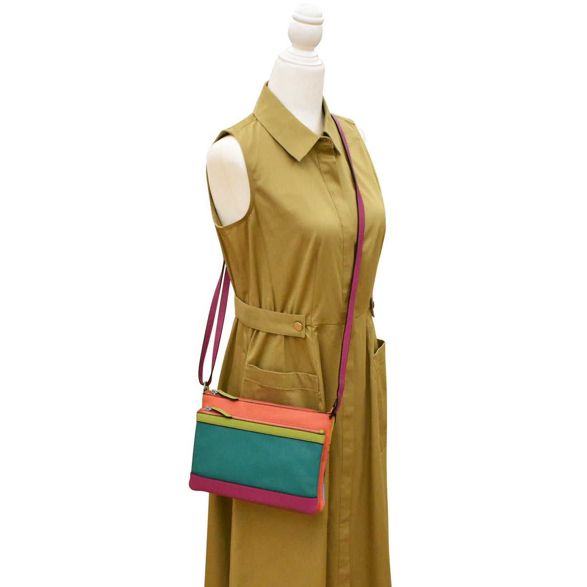 Mannequin wearing a green dress with a colorful handbag on a white background