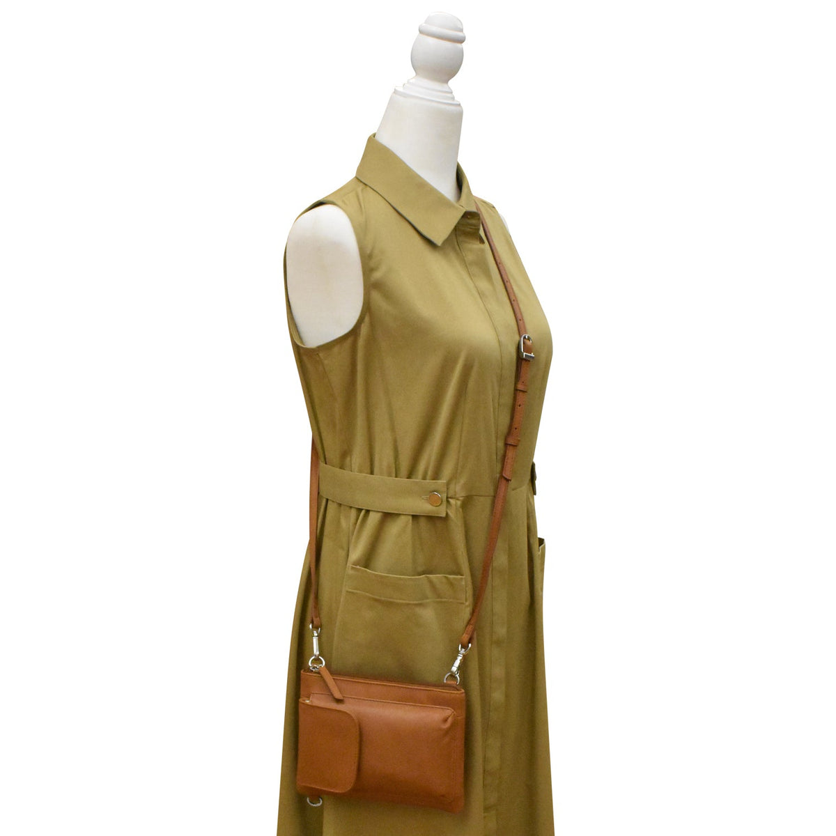 Green sleeveless dress with a brown leather bag on a mannequin against a white background