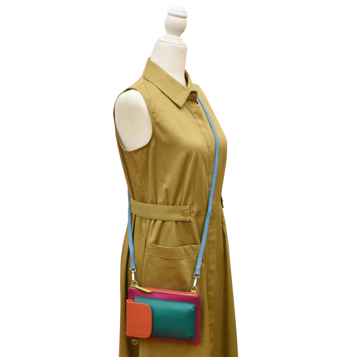 Mannequin wearing a tan dress with a colorful handbag on a white background