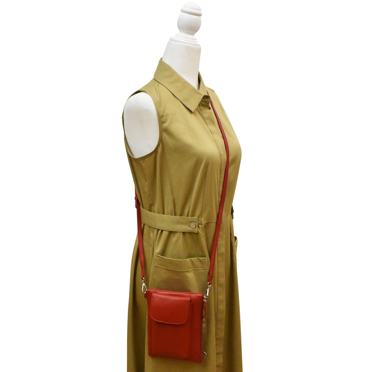 Mannequin wearing a beige dress with a red purse on a white background