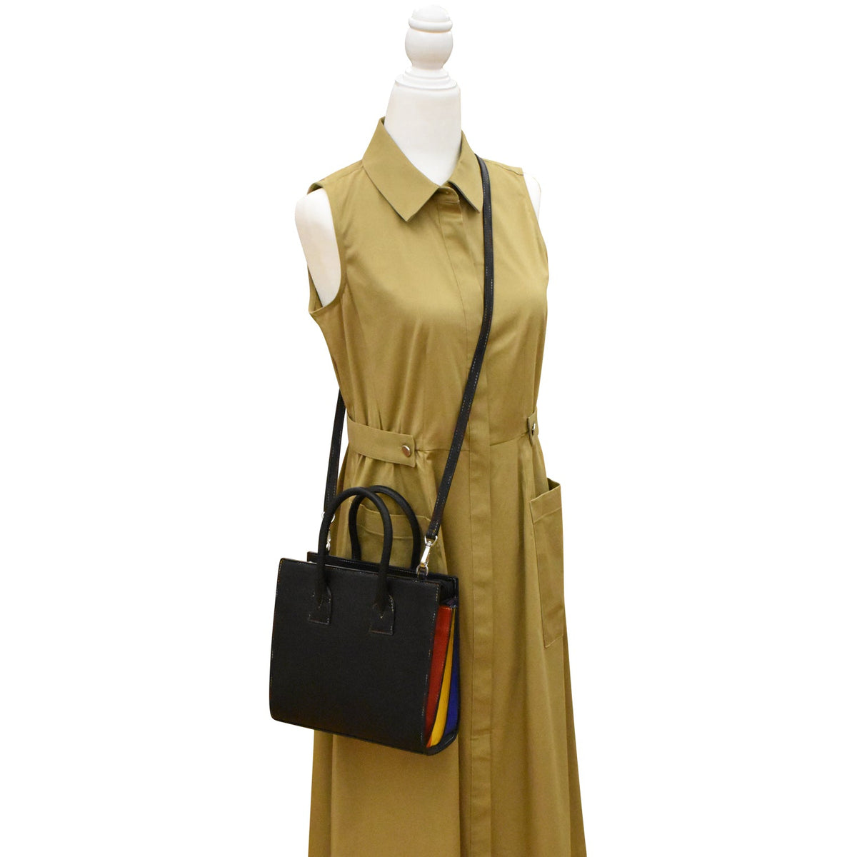 Mannequin wearing a beige dress with a black handbag featuring colorful accents on a white background