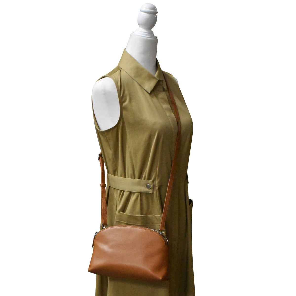 Mannequin wearing a green dress with a brown leather bag on a white background