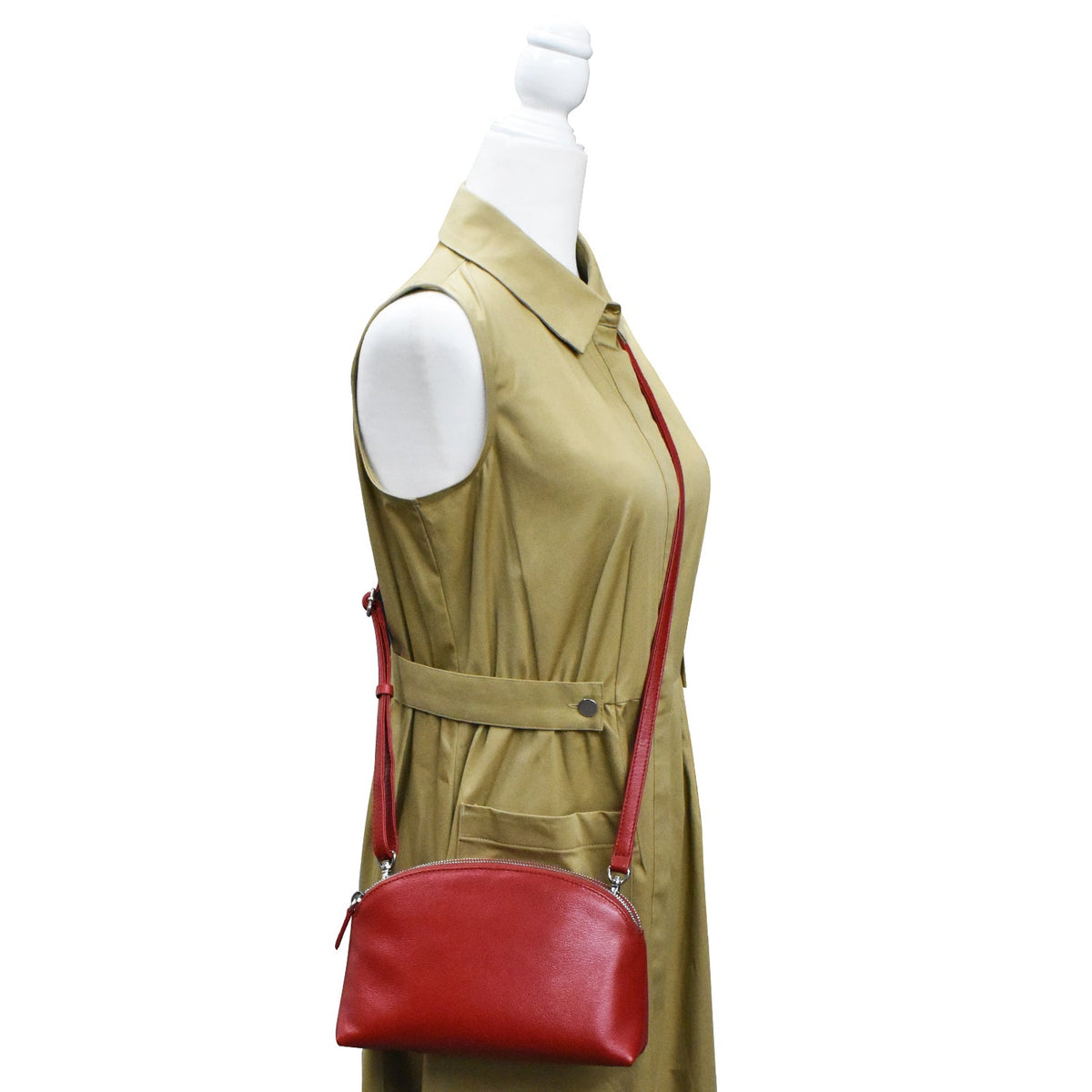 Mannequin wearing a beige dress with a red handbag on a white background