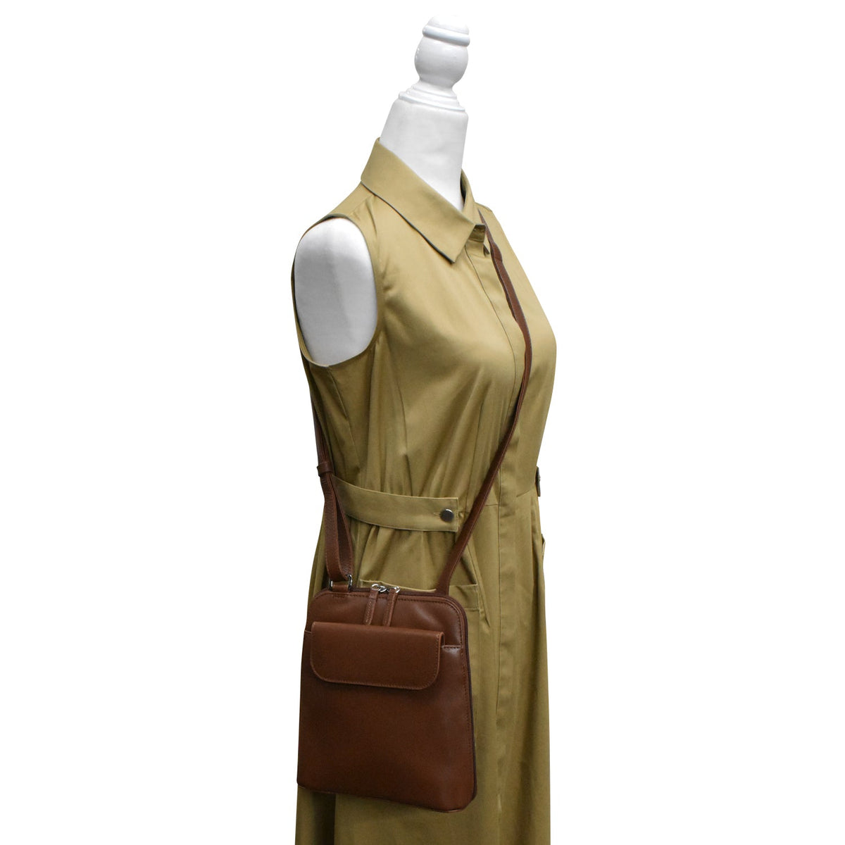 Mannequin wearing a beige dress with a brown leather bag on a white background