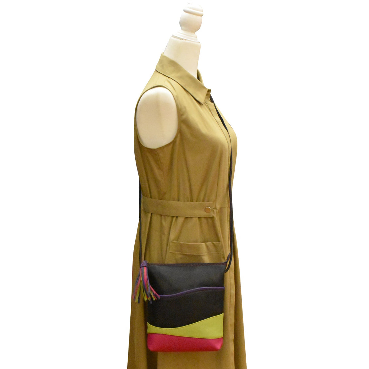 Mannequin wearing a beige sleeveless dress with a colorful handbag on a white background