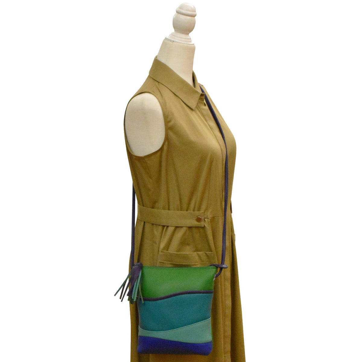 Mannequin wearing a mustard yellow dress with a green and blue handbag.