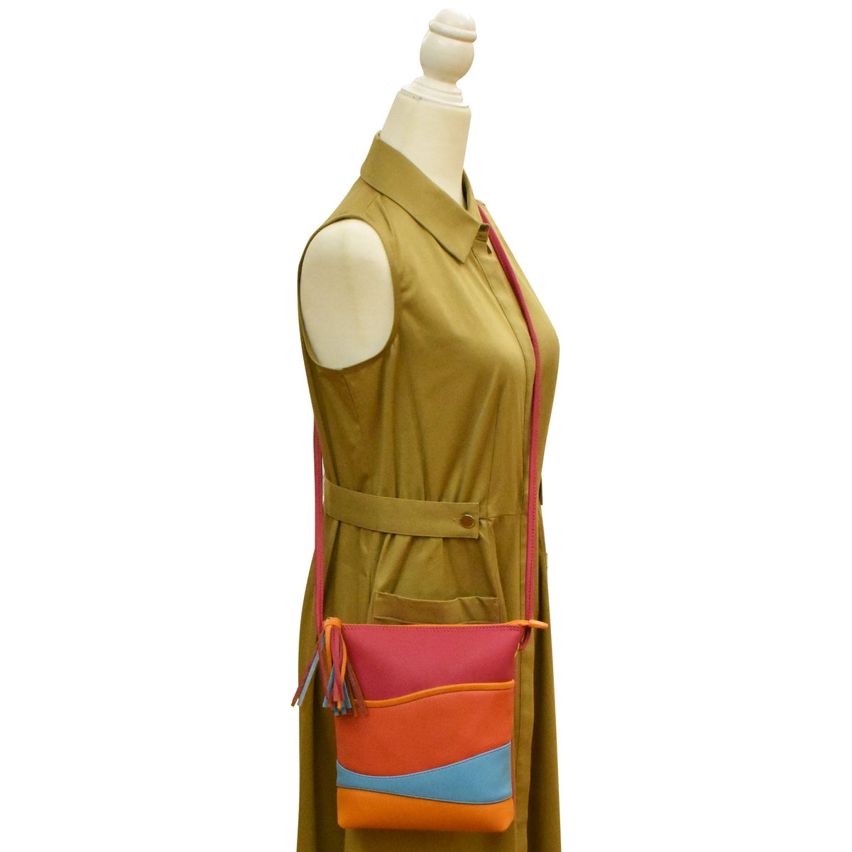 Mannequin wearing a mustard yellow dress with a colorful bag on a white background
