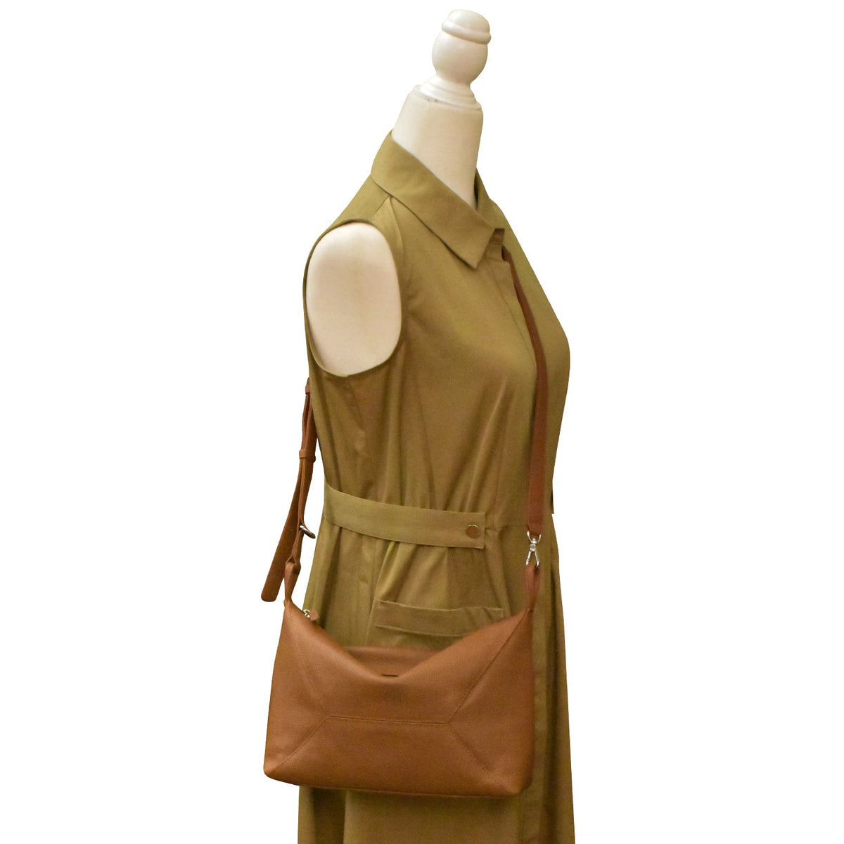 Green sleeveless dress with a brown leather bag on a mannequin against a white background