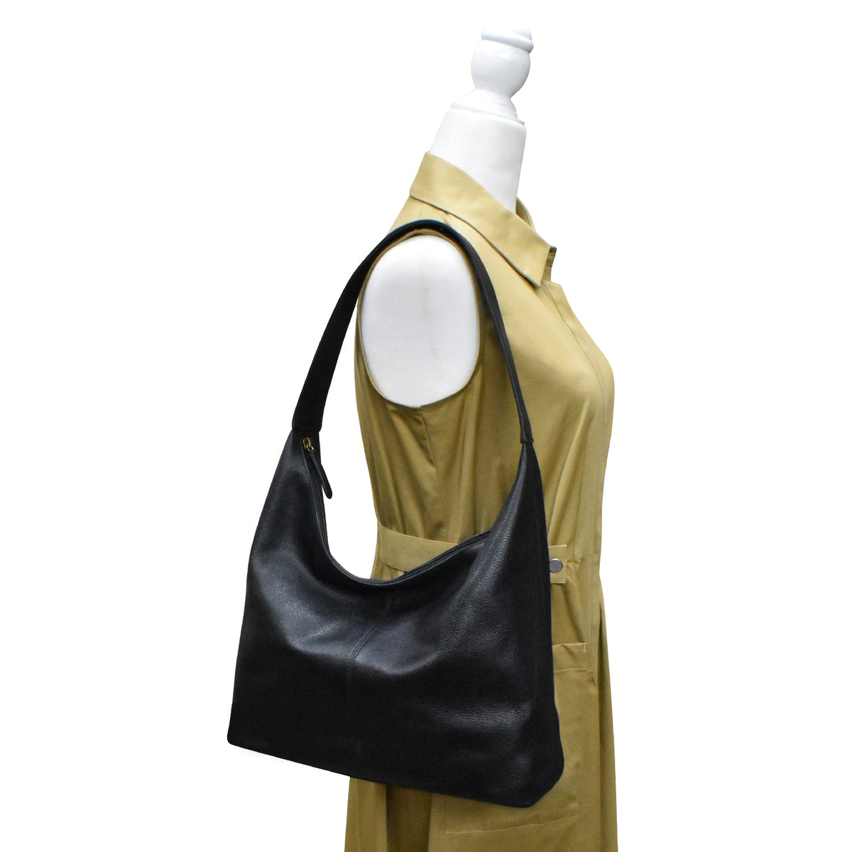 Black handbag on a mannequin with a beige shirt against a white background