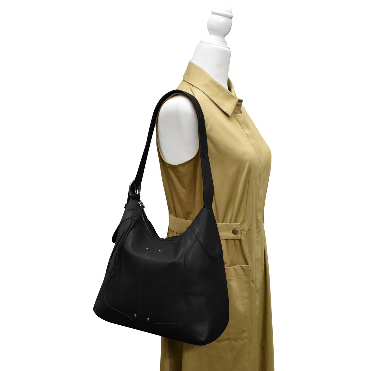 Black handbag on a mannequin with a beige dress against a white background