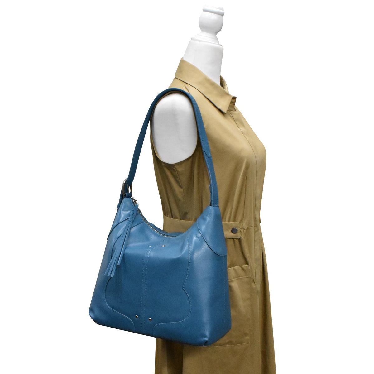 Blue handbag on a mannequin with a beige dress against a white background