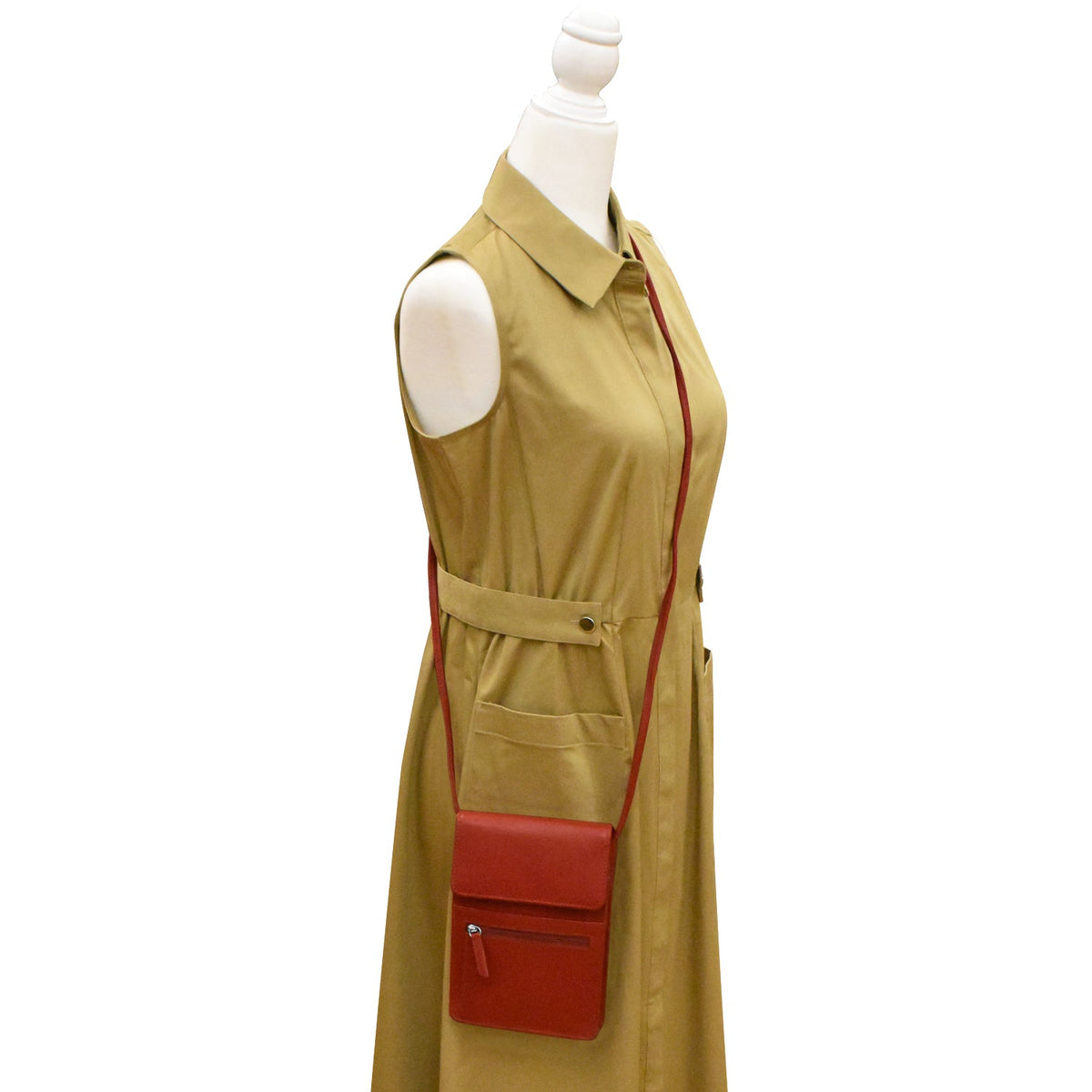 Beige sleeveless dress with a red bag on a mannequin against a white background
