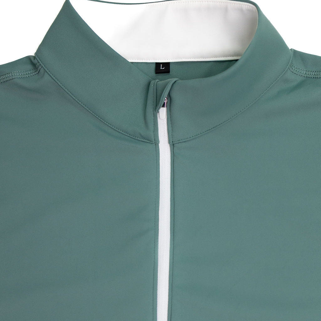 Close-up of a teal green athletic half-zip pullover with a white inner collar and a white zipper track, shown on a clean white background.