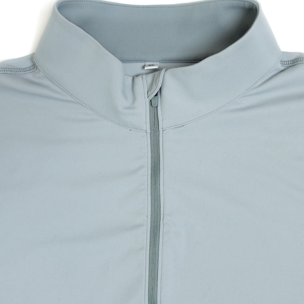 Close-up of a light blue-gray quarter-zip pullover with a stand collar and a central zipper pull, shown on a plain white background.