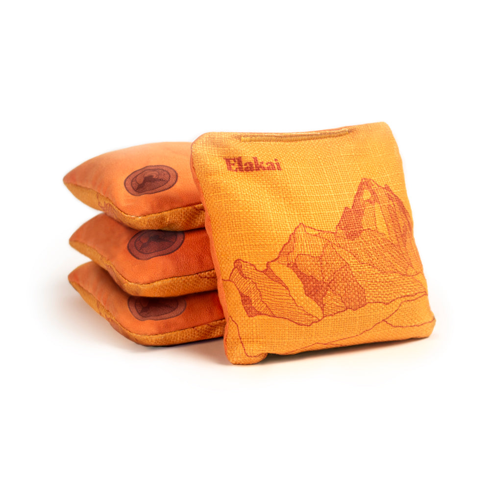 Orange bean bags with mountain design and 'Plakai' branding on a white background