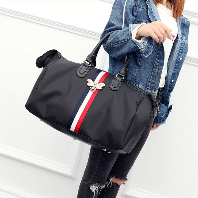 Person holding a black bag with a red and white stripe on a white background