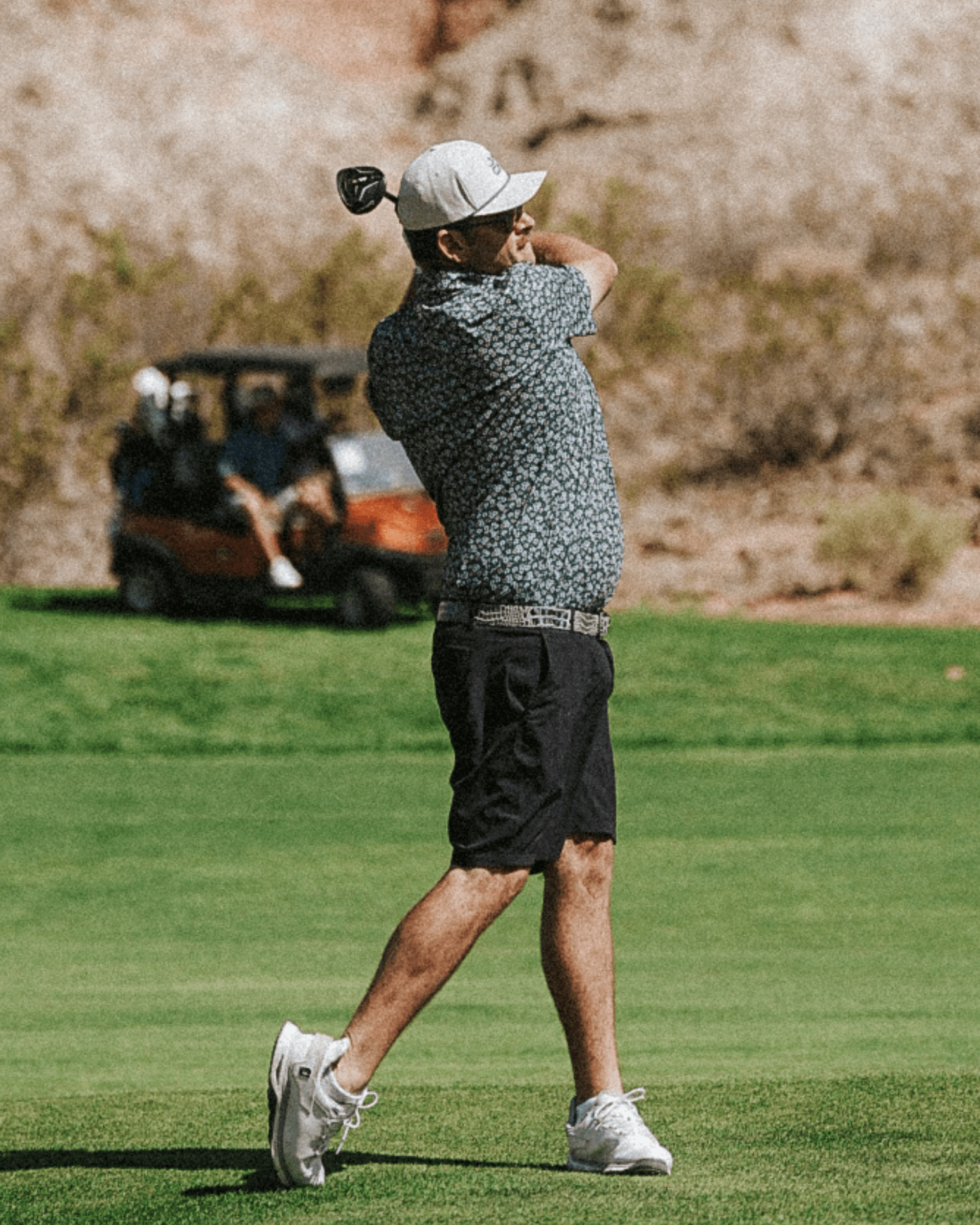 Man playing golf on a green course with a blurred background