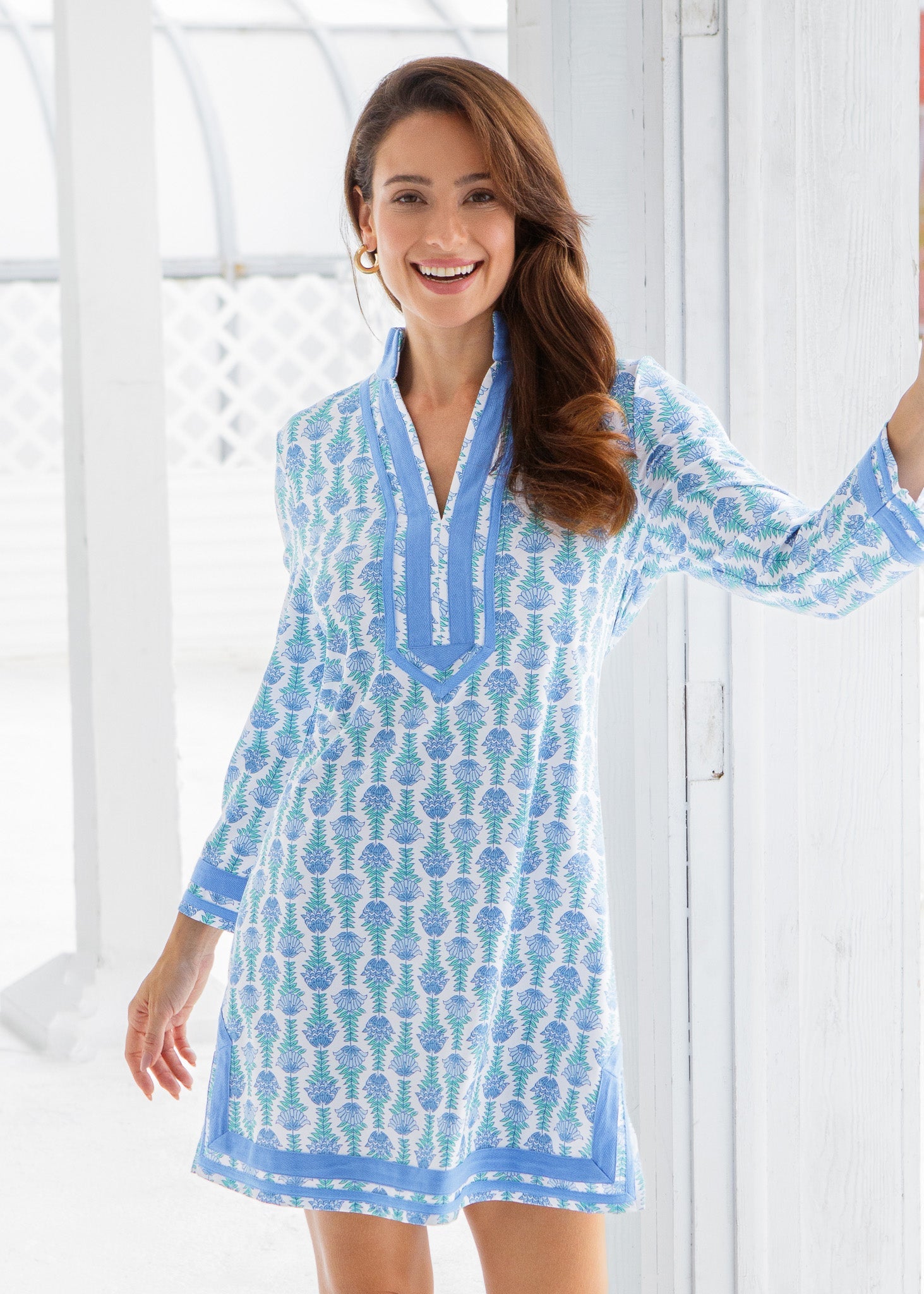 Woman wearing a blue and white patterned dress with a white background
